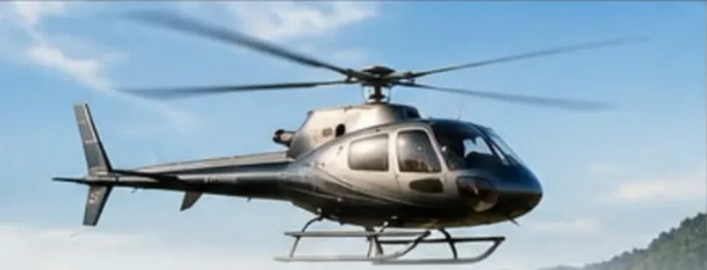 מסוק Airbus H125 אפור כהה בטיסה בשמיים כחולים